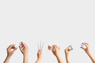 Açık arkaplanda diş, plastik diş ve çene modeli olan kişiler