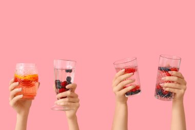 Pembe arka planda erimiş su olan birçok el