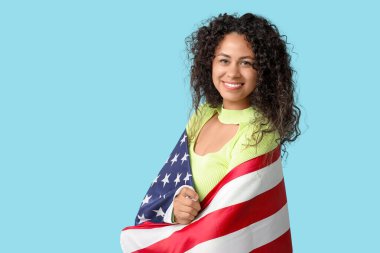 Mavi arka planda Amerikan bayrağı olan mutlu Afro-Amerikan kadın.