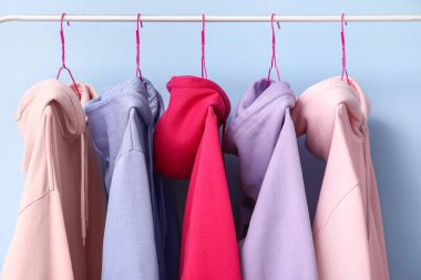 Mavi arka planda renkli kapüşonlu raflar, yakın plan.