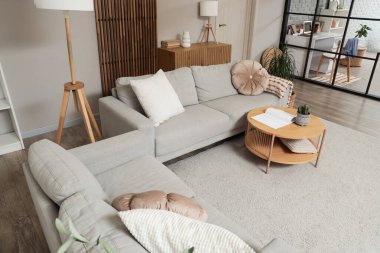 Kanepeleri, masası ve katlanabilir ekranı olan stüdyo dairesinin içi.