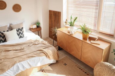 İçinde bitkiler, katlanan ekran ve tuvalet olan rahat bir yatak odası.