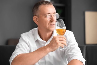 Yetişkin bir adam evde şarap tadıyor, yakından.