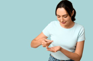 Mavi arka planda hapları olan güzel bir genç kadın.