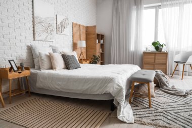 Modern ışık yatak odasının içinde büyük rahat bir yatak ve bank.