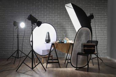 Profesyonel ekipmanı ve masası olan karanlık fotoğraf stüdyosunun içi.