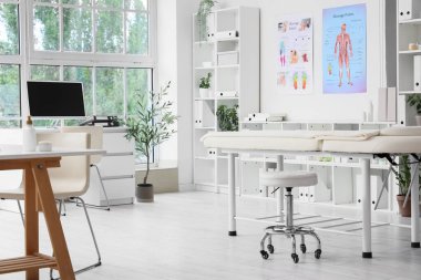 Masaj koltuğu, çalışma yeri ve raf üniteleri olan bir hastane.