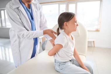 Klinikte küçük bir hastayla çalışan kadın osteopat.
