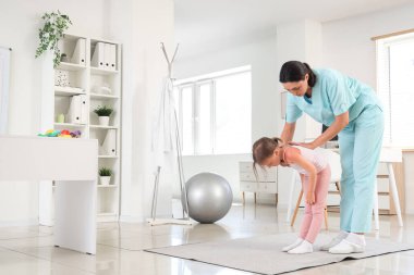 Klinikte gerinen az hasta olan kadın osteopat.