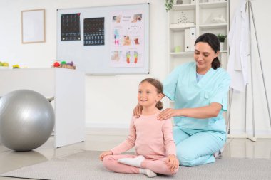 Biraz hasta esneme ve klinikte egzersiz yapan kadın osteopat.