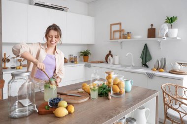Mutfakta limonata karıştıran genç kadın.