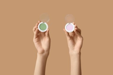 Kahverengi arka planda farklı göz farı olan kadın elleri