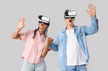 Işık arka planında VR gözlüğü kullanan genç çift