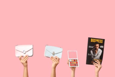 Dergisi olan kadın elleri, şık çantalar ve pembe arka planda bir palet göz falı.