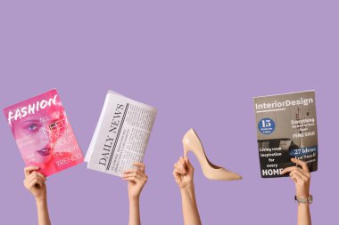 Farklı dergiler, gazeteler ve yüksek topuklu leylak arkaplanlı kadın elleri.