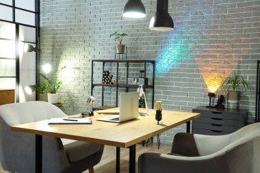 Podcaster 'ın iş yeri, raf ünitesi ve parlayan lambaları olan karanlık stüdyonun içi.