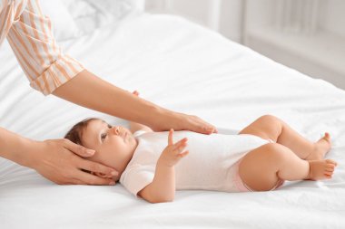 Küçük şirin bebek yatak odasında masaj yaptırıyor.