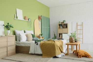 İçinde bitkiler, banklar ve çekmeceler olan şık bir yatak odası.