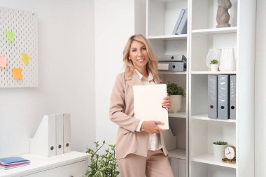 Ofisinde klasörü olan güzel iş kadını.