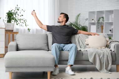 Evdeki klimayı açan yakışıklı genç adam.