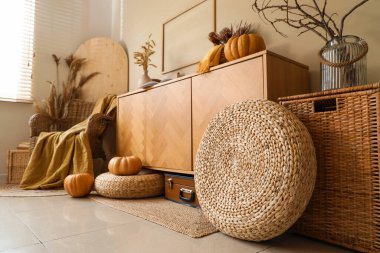 Örgülü koltuk, balkabağı, ekose, kanepe ve çekmeceler sonbahar salonunda.