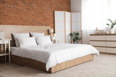 Işıl ışıl yatak odasının içi, rahat yatak odası ve beyaz katlanır ekran.