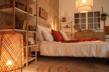 Karanlık yatak odasının içinde rahat bir yatak odası ve parlak lambalar var.