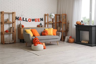 Cadılar Bayramı partisi için dekore edilmiş kanepesi, şöminesi, balkabağı ve disko topu olan şık bir oturma odası.