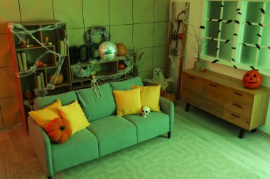 Cadılar Bayramı partisi için dekore edilmiş disko topu ve yumuşak kanepeli şık bir oturma odası.