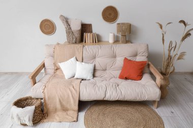 Konforlu kanepe, otlar ve salonun içinde ekoseli hasır sepet.