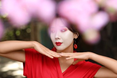 Geleneksel giysiler içinde güzel bir geyşa ve şehir sokaklarında sakura.
