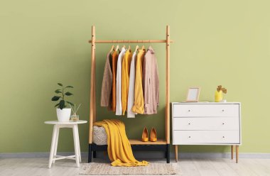 Giysi askısı, masa ve çekmeceleri olan bir soyunma odası.