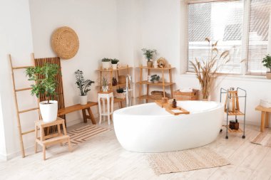 Banyonun içinde bank, küvet ve bitkiler var.