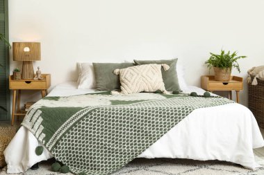 Yatak odasının iç tarafında komodinli rahat bir yatak.