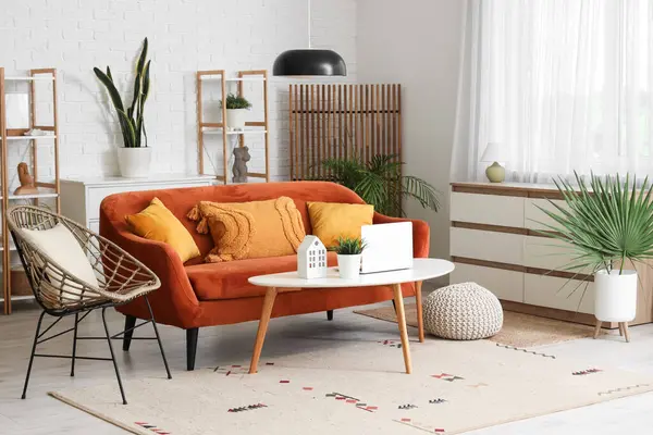 Oturma odasının içi kırmızı kanepe, koltuk ve ahşap perdeli.