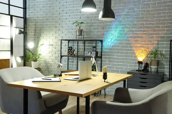 Podcaster 'ın iş yeri, raf ünitesi ve parlayan lambaları olan karanlık stüdyonun içi.