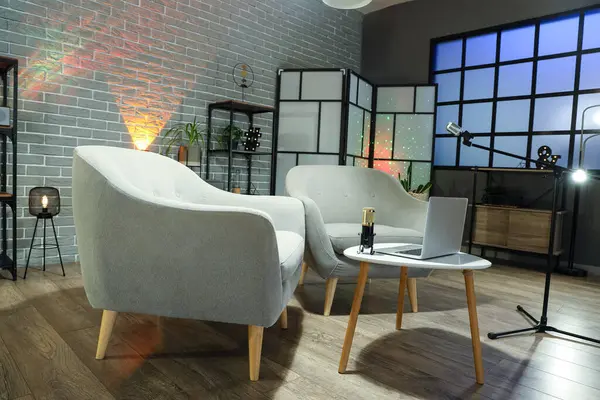 Podcaster 'ın iş yeri, mikrofonlar ve parlayan lambalar olan karanlık stüdyonun içi.