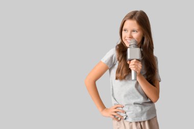 Gri arka planda modern mikrofonu olan tatlı bir kız.