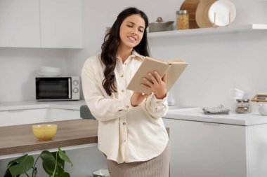 Mutfakta çay fincanı okuyan güzel genç bir kadının portresi.