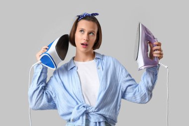 Gri arka planda ütüler ile genç kadın