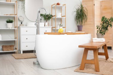 Banyonun içinde küvet ve ahşap bank var.