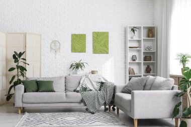 Oturma odasının içinde rahat koltuklar ve resimler var.