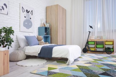 Yataklı, raflı ve scooterlı çocuk odasının içi.