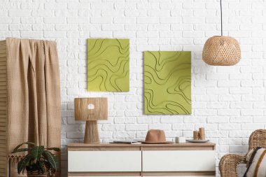 Çekmeceler, katlanan ekran ve beyaz tuğla duvarlı resimler.