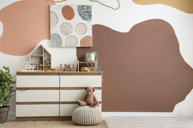 Tuvalet, resim ve oyuncaklarla dolu bir kreş.