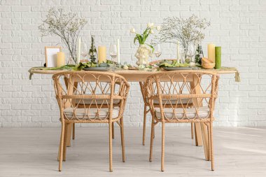 Hafif yemek odasında güzel çiçekler ve mumlar olan zarif bir masa.