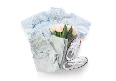 Beyaz arka planda şık çocuk kıyafetleri, gözlükleri, ayakkabıları ve çiçekleri olan kompozisyon