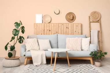 Gri kanepe, masa ve merdivenli oturma odasının içi.