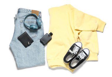 Beyaz arka planda şık erkek kıyafetleri, ayakkabıları, aksesuarları ve modern kulaklıkları olan kompozisyon