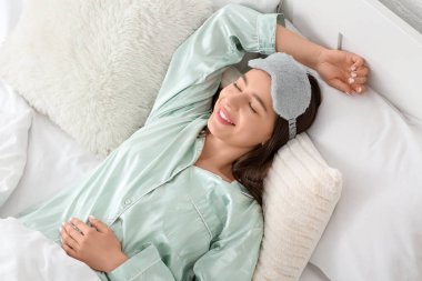 Mutlu genç bir bayanın yatak odasında uzandığı bir sabah.